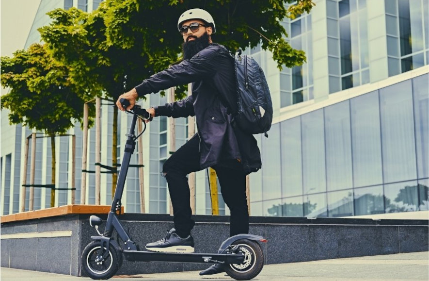 Man på elsparkcykel i urban miljö